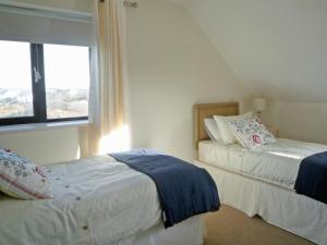 two beds in a room with a window at Cnocan Na Cuaig Carraroe by Trident Holiday Homes in Carraroe