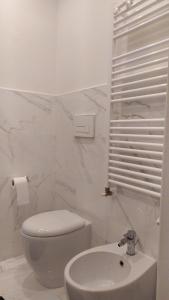 a white bathroom with a toilet and a sink at B&B Suite 44 in Pesaro