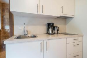 a kitchen with white cabinets and a sink at Residence Kronstein - Fewo 4 in Tesimo