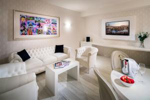 sala de estar con sofá blanco y mesa en Base Hotel, en Noventa di Piave