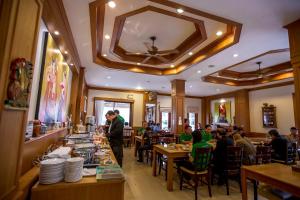 a restaurant with people sitting at tables in a restaurant at Loei Village Hotel in Loei