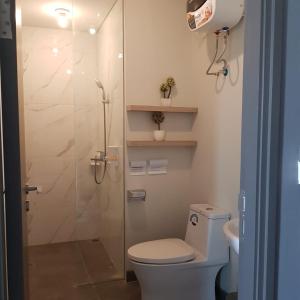 a bathroom with a toilet and a glass shower at One Residence #11AI in Batam Center