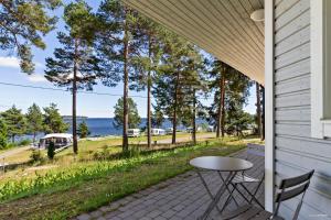 een patio met een tafel en stoelen aan de zijkant van een huis bij First Camp Fläsian - Sundsvall in Sundsvall