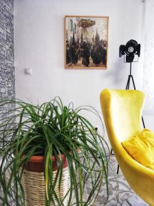 a living room with a yellow chair and a plant at Casa Princesa Huelin in Málaga