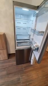 ein leerer Kühlschrank mit offener Tür in einem Raum in der Unterkunft Zimmervervietung Bei Lachajczyk in Bad Salzdetfurth