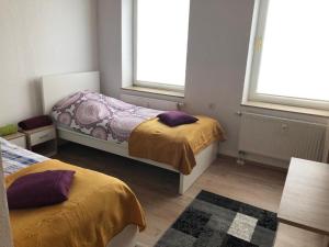 zwei Betten in einem Zimmer mit zwei Fenstern in der Unterkunft Zimmervervietung Bei Lachajczyk in Bad Salzdetfurth