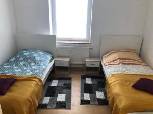 zwei Betten in einem kleinen Zimmer mit Fenster in der Unterkunft Zimmervervietung Bei Lachajczyk in Bad Salzdetfurth