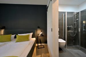 ein Schlafzimmer mit einem Bett, einer Dusche und einem WC in der Unterkunft Hotel- & Ferienanlage Kapitäns-Häuser Breege in Breege