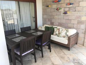 een tafel en stoelen en een bank op een patio bij Indulge and Relax Apartment in Pipa