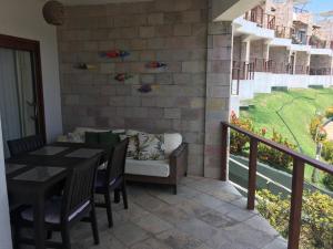 een patio met een bank en een tafel en stoelen bij Indulge and Relax Apartment in Pipa