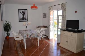 ein Esszimmer mit einem Tisch, Stühlen und einem TV in der Unterkunft Central Tavira apartment, Casa Oliverio in Tavira