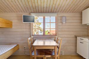 a dining room with a table and a tv on a wall at First Camp Fläsian - Sundsvall in Sundsvall