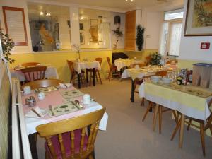 une salle à manger avec des tables et des chaises dans un restaurant dans l'établissement Haven House, à Torquay