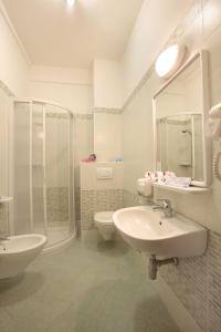 a bathroom with a sink and a toilet and a shower at Hotel Abacus in Cesenatico