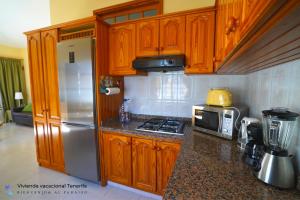 cocina con armarios de madera y nevera de acero inoxidable en Miriana, en Abades