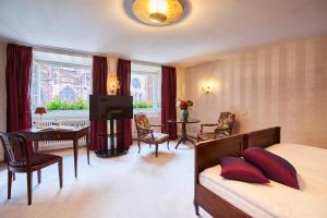 a hotel room with a bed and a desk and a television at Boutiquehotel Oberkirch im Zentrum in Freiburg im Breisgau