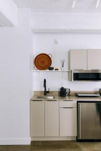 una cocina con armarios blancos y fregadero en Maison Sainte-Thérèse By Maisons & co, en Montreal