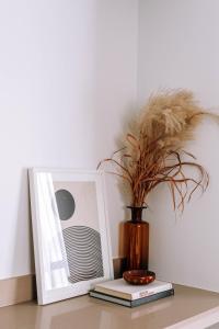 a vase sitting on a table next to a picture at Maison Sainte-Thérèse By Maisons & co in Montreal