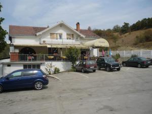 a house with cars parked in a parking lot at Motel Stara Vrba in Kuršumlija