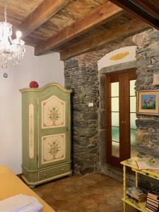 a room with a green cabinet next to a stone wall at Affittacamere Le Terrazze in Corniglia