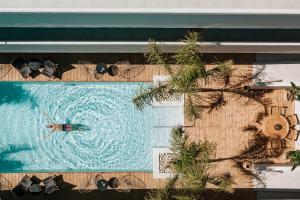 a person swimming in a swimming pool with sunglasses at More Meni Residence & Suites in Tigaki