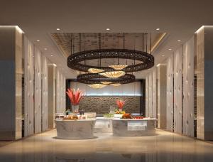 un vestíbulo con una gran lámpara de araña y una mesa en Yangzhong Firth Jinling Grand Hotel, en Yangzhong