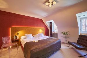 1 dormitorio con 1 cama grande y pared roja en Boutiquehotel Oberkirch im Zentrum, en Freiburg im Breisgau