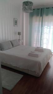 een slaapkamer met een groot wit bed en een raam bij Casa O'lado in Golegã