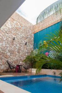 Casa con piscina y pared de piedra en Latino Hotel Boutique, en Tulum