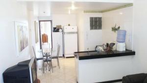 a kitchen with a counter and a tv in a room at JANELA SOBRE O MAR DE GUARAPARI in Guarapari