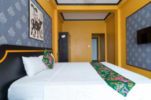 um quarto com uma grande cama branca com paredes amarelas em VietHouse Homestay Ha Long em Ha Long