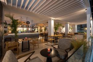 a restaurant with tables and chairs and a bar at More Meni Residence & Suites in Tigaki
