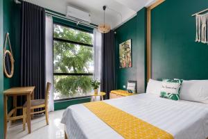 een slaapkamer met een bed en een groene muur bij VietHouse Homestay Ha Long in Ha Long