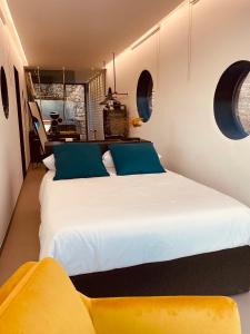 a bedroom with a large white bed with blue pillows at Container Suite in Terrasini