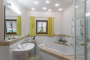 a white bathroom with a tub and a sink at Landhaus Stephanie in Krün +13 photos