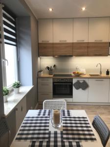 a kitchen with a table with a checkered table cloth at Apartament BARCELONA in Białystok