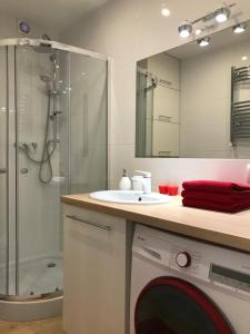 a bathroom with a sink and a washing machine at Apartament BARCELONA in Białystok