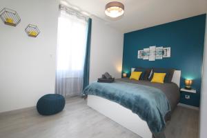 1 dormitorio con 1 cama con pared azul en Le First by EasyEscale, en Romilly-sur-Seine