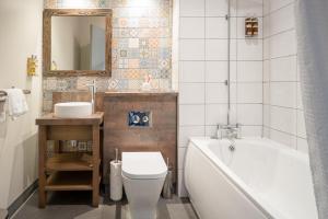 a bathroom with a tub and a toilet and a sink at Abel Heywood Boutique Hotel in Manchester
