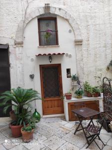 una casa con una porta in legno e piante in vaso di B&B Sant'Anna a Bari