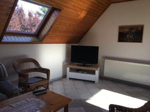 a living room with a flat screen tv and a table at Badacsony Apartmanház in Badacsonytomaj