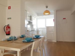 a dining room with a table with blue bowls on it at Sol Da Caparica in Costa da Caparica