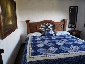 a bedroom with a bed with a blue and white quilt at Finca Sanfelipe in Calima