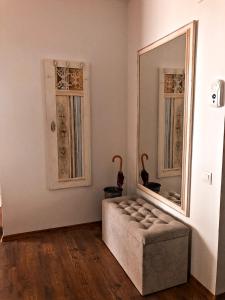 een woonkamer met een poef en een spiegel bij Vintage touch apartment in Cluj-Napoca
