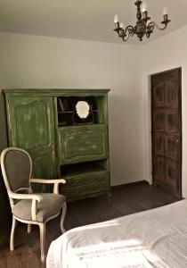 a bedroom with a green dresser and a chair at Vintage touch apartment in Cluj-Napoca