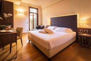 a bedroom with a large bed and a table and a desk at Hotel Alla Torre in Castelfranco Veneto