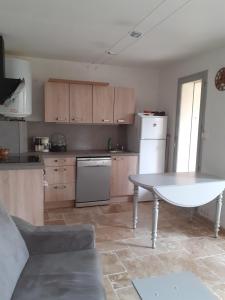 a kitchen with a white table and a white refrigerator at RESIDENCE PORTO DI MAR CAVALAIRE in Cavalaire-sur-Mer