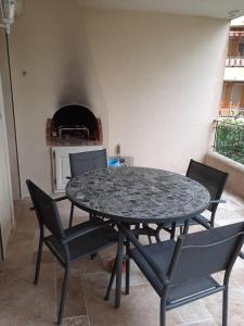 a table and chairs in a room with a fireplace at RESIDENCE PORTO DI MAR CAVALAIRE in Cavalaire-sur-Mer +2 photos