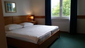 A bed or beds in a room at Hotel Nümbrecht