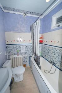 a bathroom with a toilet and a tub and a sink at Loft Hostel Minsk in Minsk